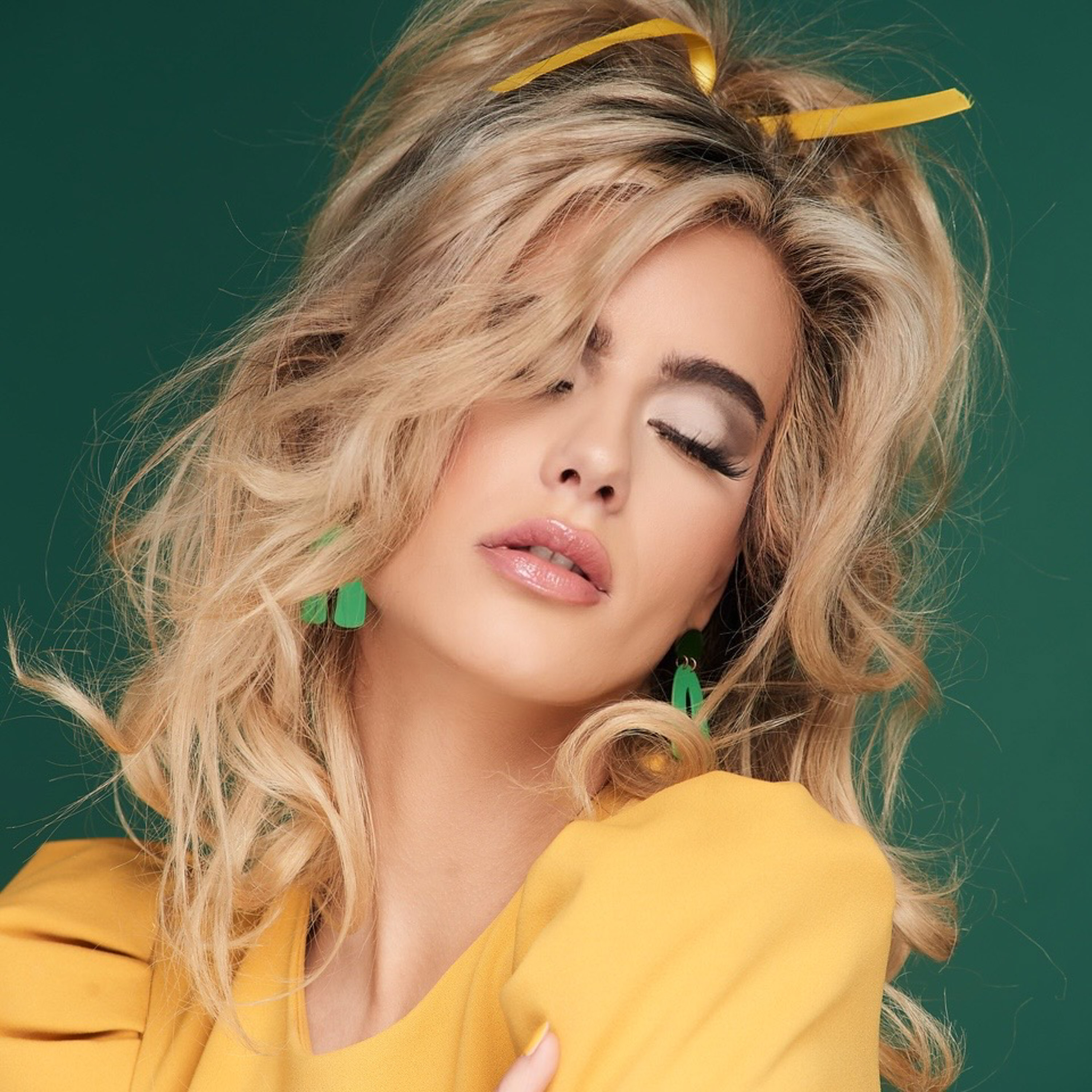 Dawn Muensterman in a marigold puff-sleeve jacket against an emerald backdrop